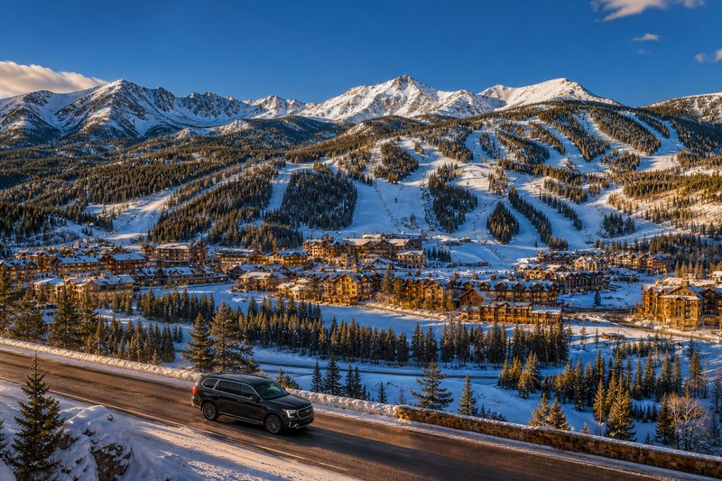 Colorado ski resort with luxury SUV on mountain highway